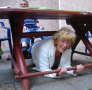 Regisseurin Gisela Noll verkriecht sich unter dem Tisch